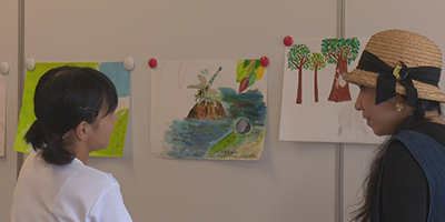 写真：壁に飾られた作品をみる蟹江杏さんと子供