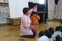写真：節分の帽子をかぶった1歳児の子ども