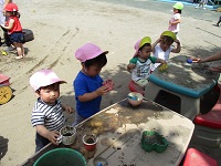 1歳児が砂場で遊んでいるところの写真