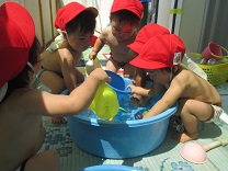 写真：1歳児が集まって水遊びしている