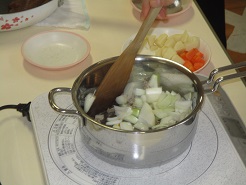 カレーを作るために野菜を炒めている写真