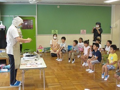 栄養士が子どもたちの前で調理実演をしている写真
