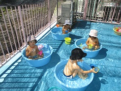 一歳児がたらいプールに入っている写真