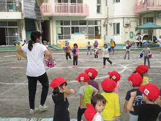 4歳児（ぱんだ組）と一緒に踊る2歳児（うさぎ組）の写真