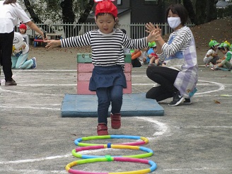 2歳児（うさぎ組）フラフープを飛び越えている写真