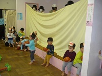 1歳児りす組がホールで運動会ごっこをしている写真
