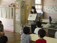 5歳児らいおん組が調理活動の事前指導で栄養士の話を聞いている写真