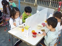 できた芋汁を食べる子どもの写真