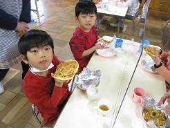 焼きあがったピザを子どもが食べている写真