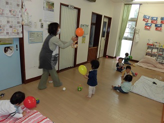 0歳児ひよこ組が室内で風船を使って遊んでいる様子の写真
