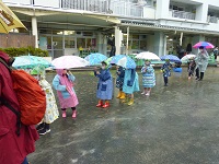 傘をさして出かける子どもの写真