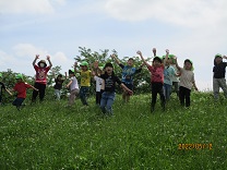 写真：5歳　芝生で手を挙げる