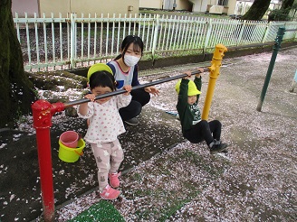 2歳児が鉄棒で遊んでいる様子の写真