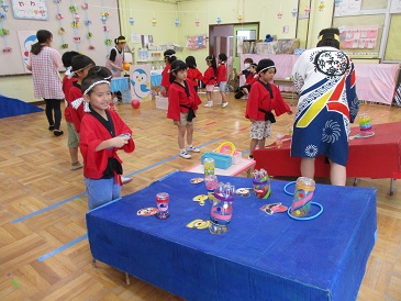 5歳児らいおん組が輪投げコーナーで遊んでいる様子の写真