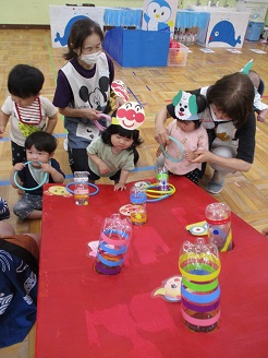 0歳児ひよこ組がわなげコーナーで遊んでいる様子の写真