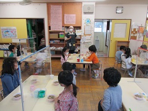 5歳児が食育活動で栄養士の話を聞いている様子の写真