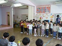3歳児こあら組と4歳児ぞう組が5歳児らいおん組にお祝いの歌を歌っている写真