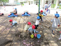 園庭で2歳児うさぎ組4歳児ぱんだ組の子どもたちが遊んでいる様子の写真
