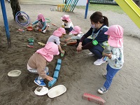 2歳児クラスが砂あそびをしている写真です。