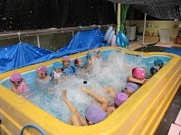 5歳児らいおん組がプールでバタ足をしている写真です。