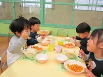 ホールで会食する3歳児の写真