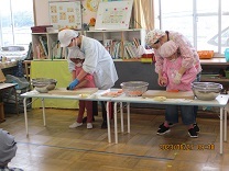 子どもが野菜を切る写真