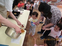 子どもが鍋を覗いている写真