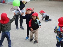 うちわで風船を打って練習する子どもの写真
