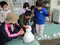 雪だるまを作る子どもの写真