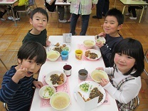 4，5歳児一緒にグループで、会食をする子どもの写真