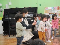 顔にかわいい鳴戸を貼ってラーメン体操をする1歳児の写真