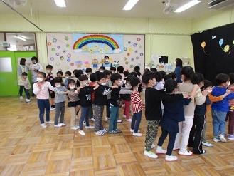 4、5歳児クラスがホールで一緒にゲームを楽しむ様子の写真