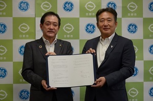 協定書を掲げる大坪市長と多田社長兼CEO