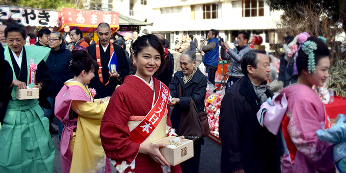 写真：節分の日に年男の行列が豆を配る姿