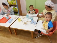 給食を食べている0歳児の様子の写真