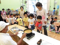 出来上がったカレーを見ている子ども達の写真