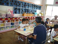小学校の先生と給食を食べる5歳児クラスの写真