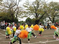 ポンポン持って踊る3歳児の様子