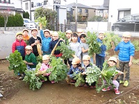 大根と記念撮影する子ども達の写真