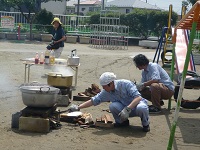 園庭のかまどでカレーを作っている写真