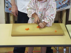 子どもが野菜を切っている様子