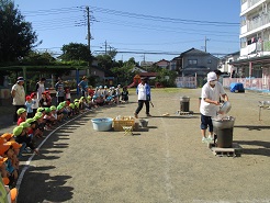 保育園の庭で、芋煮会をしている写真