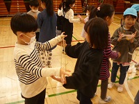 第八小学校であやとりをして遊んでいる写真