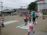 2歳児うさぎ組の子どもたちが横断歩道を渡る練習をしている写真