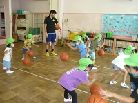 5歳児らいおん組がバスケットボールでドリブルを練習している写真