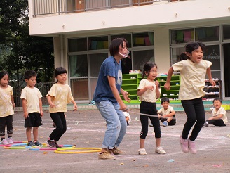 お友だちをタイミングをあわせて大縄跳びをとんでいる様子の写真