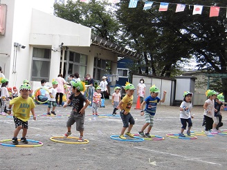 3歳児が笑顔で踊りを発表している様子の写真