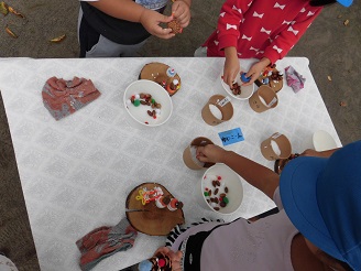 4歳児(ぱんだ組）がどんぐりや松ぼっくりを使って製作をしている写真