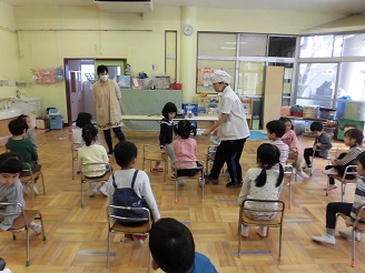 芋汁作りのデモンストレーションで材料を子どもが見せてもらっている写真