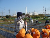 4歳児ぞう組がせせらぎ農園の人の話を聞いている写真